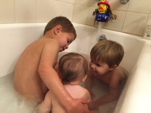 Audrey having her first big girl bath with her brothers